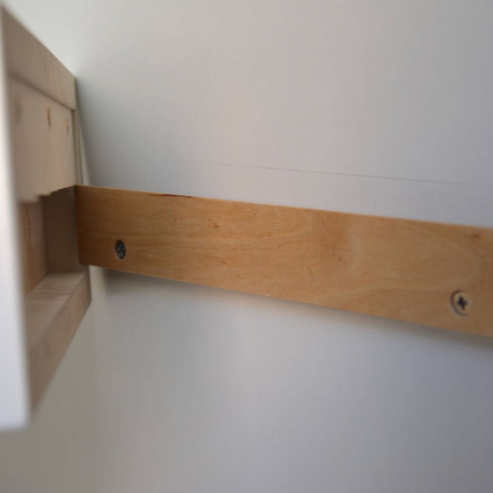 White floating nightstand with drawer and an extra shelf